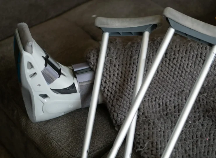 persona con bota ortopedica y muletas por un accidente