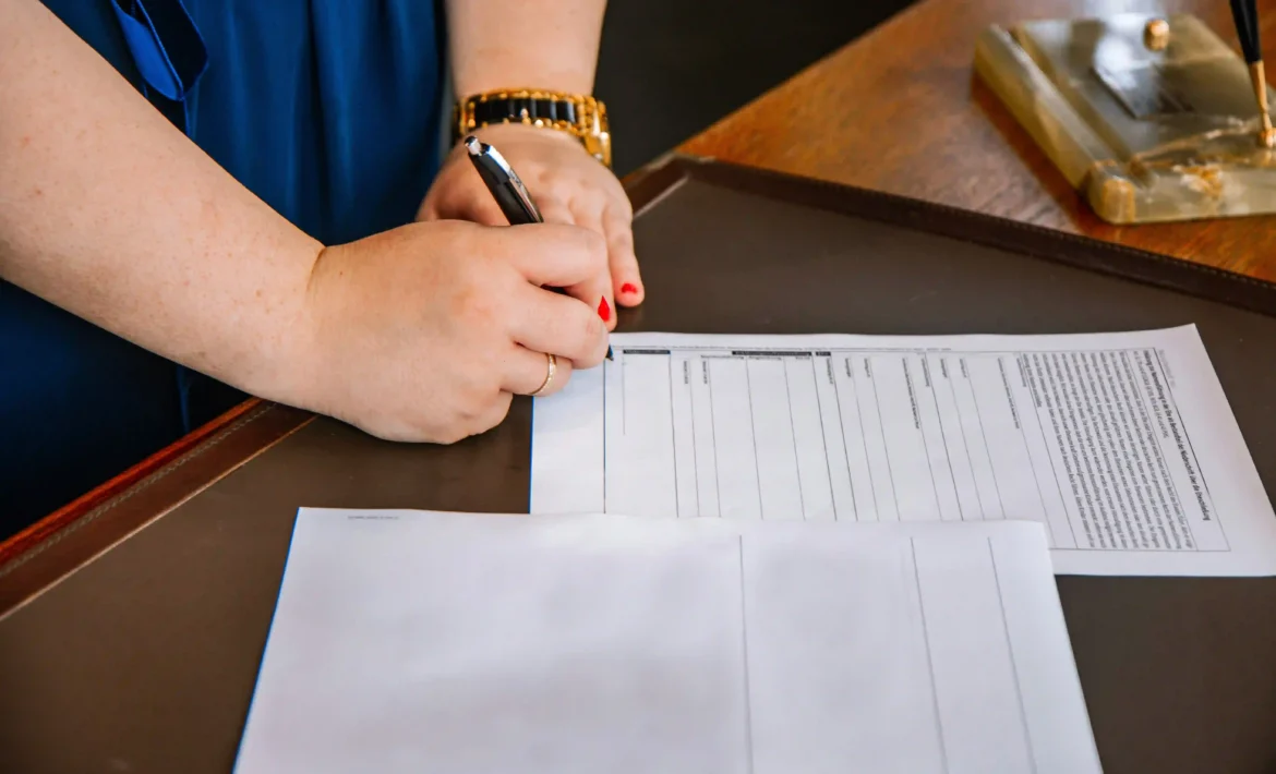 mujer firmando contrato en el escritorio de su abogado